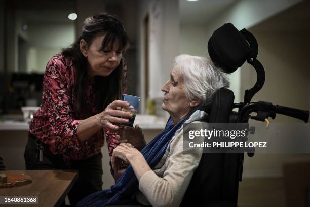 Healthcare personnel helps a patient with Alzheimer during lunch time in one of the living quarters of the village Landais Alzheimer site for...