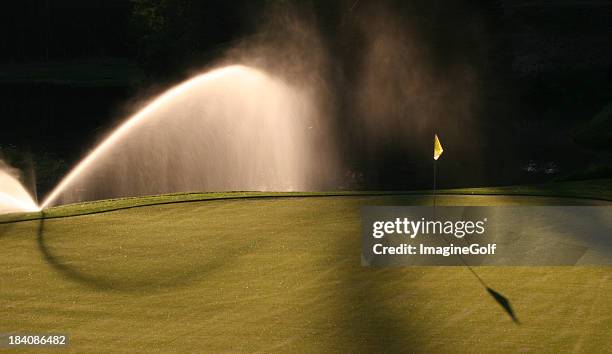 watering the golf green - golf course maintenance stock pictures, royalty-free photos & images