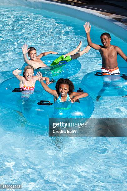 multiracial children on innertubes at water park - trögflytande bildbanksfoton och bilder