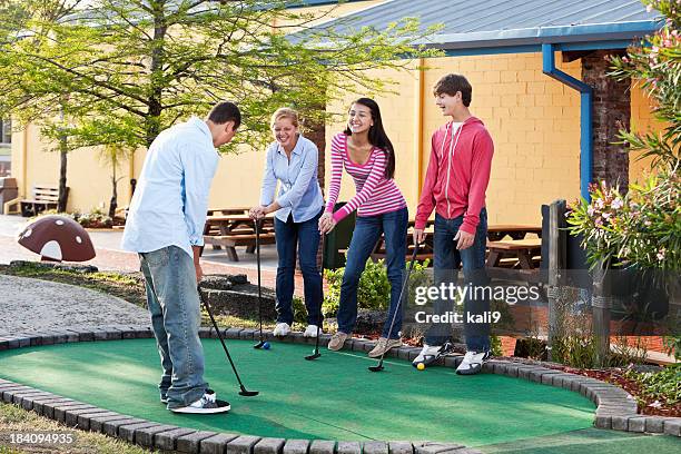 teenagers playing miniature golf - miniature golf stock pictures, royalty-free photos & images