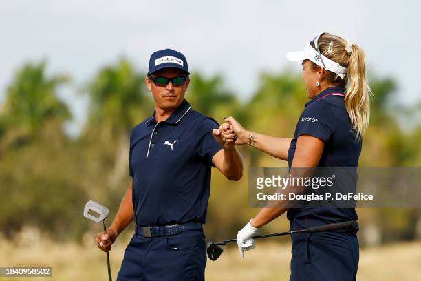 Rickie Fowler of the United States and Lexi Thompson of the United States bump fists on the ninth green during the first round of the Grant Thornton...