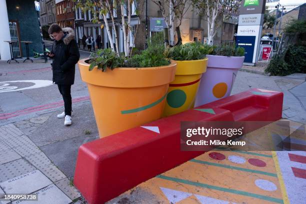 People interacting with large scale flower pot outside on Southwark Street on 15th November 2023 in London, United Kingdom.