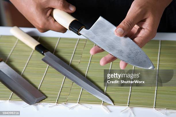 holding a sushi knife - tafelmes stockfoto's en -beelden