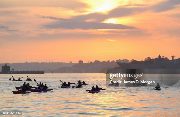 Group of kayakers make their way across Sydney Harbour at sunrise on December 09, 2023 in Sydney, Australia. A severe heat wave was predicted for the...