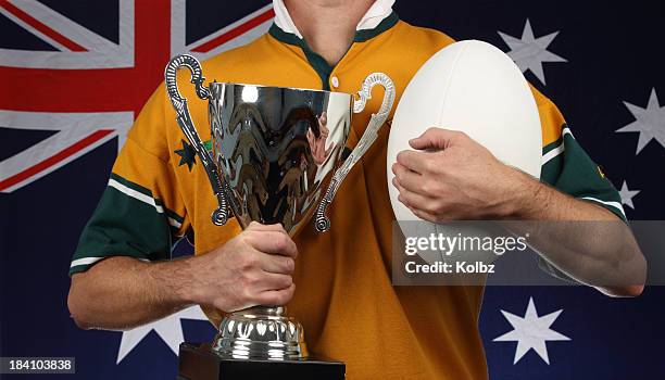 man with trophy and rugby ball in front of australian flag - australia rugby union stock pictures, royalty-free photos & images