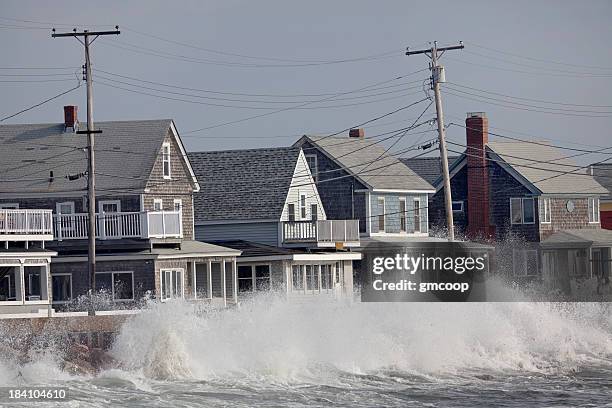 oceano che si infrangono le onde in tempesta seawall davanti case - alta marea foto e immagini stock