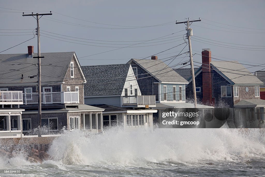 Ocean Storm Waves Crashing into Seawall in front of Houses