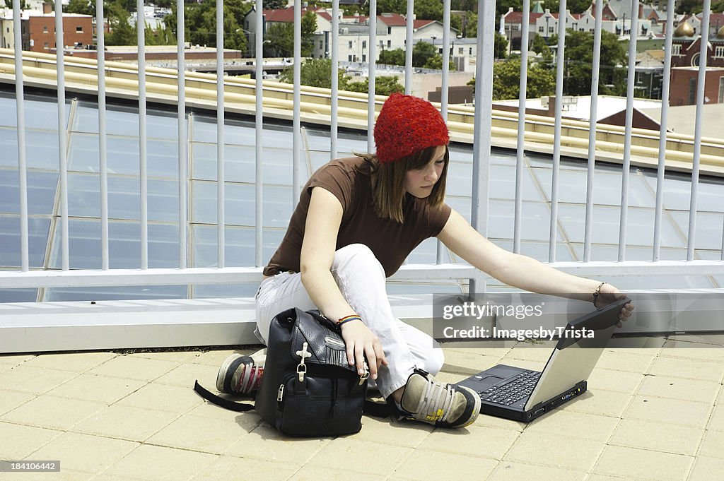 Rapariga urbana com computador portátil