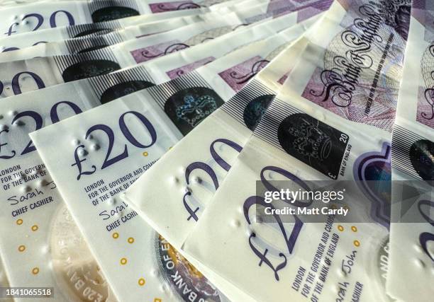 In this photo illustration, £20 notes featuring the late Queen Elizabeth II are pictured on December 02, 2023 in Bath, England. The year ahead is...