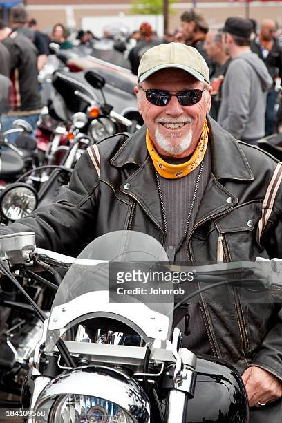 biker im rally sitzt auf dem motorrad und lächeln - bike rally stock-fotos und bilder