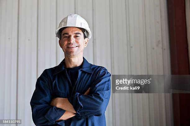 hispanic arbeiter mit schutzhelm - helm stock-fotos und bilder
