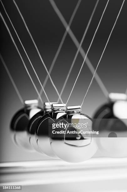 1 silver ball in newton’s cradle swings back toward others - newtons cradle stockfoto's en -beelden