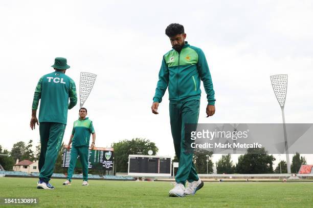 Pakistan players walk from the field during a delay to the start of play due to an overnight storm during day four of the Tour match between PMs XI...