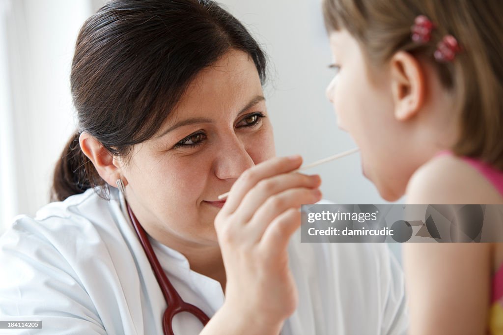 Mujer de niño throath comprobación al pediatra