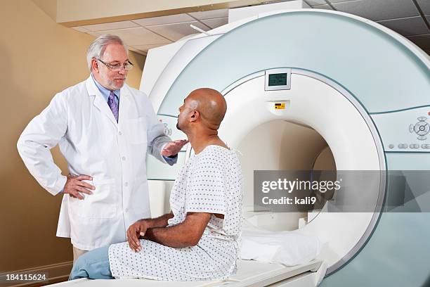 doctor talking to patient getting mri scan - hospital gown stock pictures, royalty-free photos & images