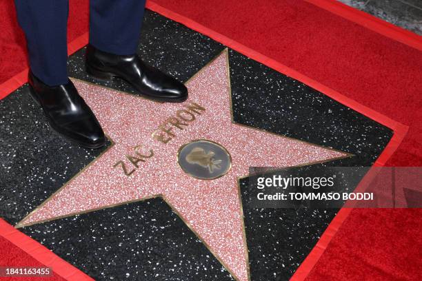 Actor Zac Efron stands on his newly unveiled star during his Hollywood Walk of Fame ceremony in Hollywood, California, on December 11, 2023.