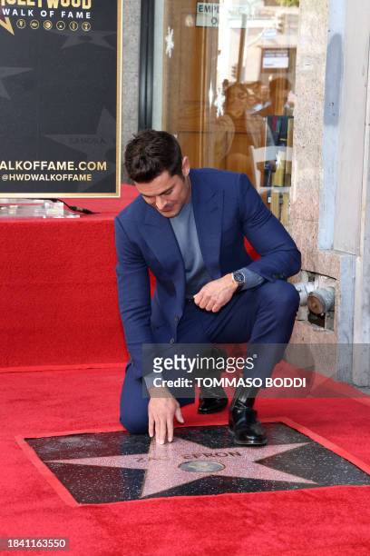 Actor Zac Efron poses by his newly unveiled star during his Hollywood Walk of Fame ceremony in Hollywood, California, December 11, 2023.