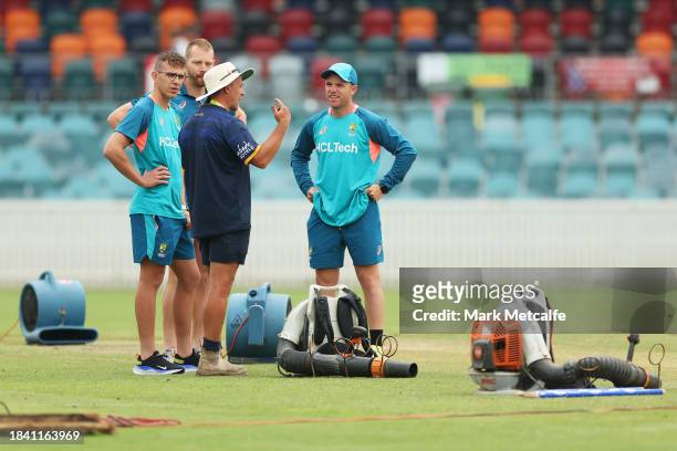 Marcus Harris; Todd Murphy and Nathan McAndrew of the Prime Ministers XI talk to ground staff during a delay to the start of play due to an overnight...
