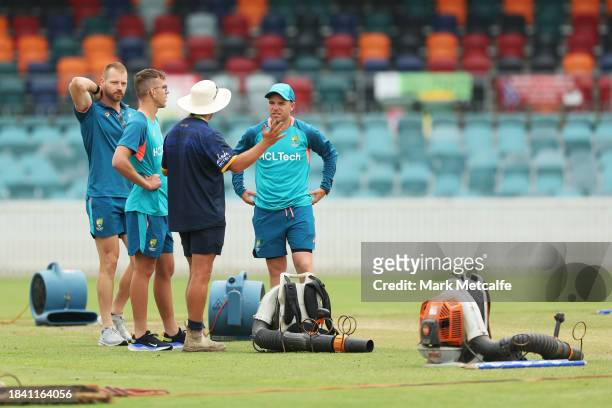 Marcus Harris; Todd Murphy and Nathan McAndrew of the Prime Ministers XI talk to ground staff during a delay to the start of play due to an overnight...