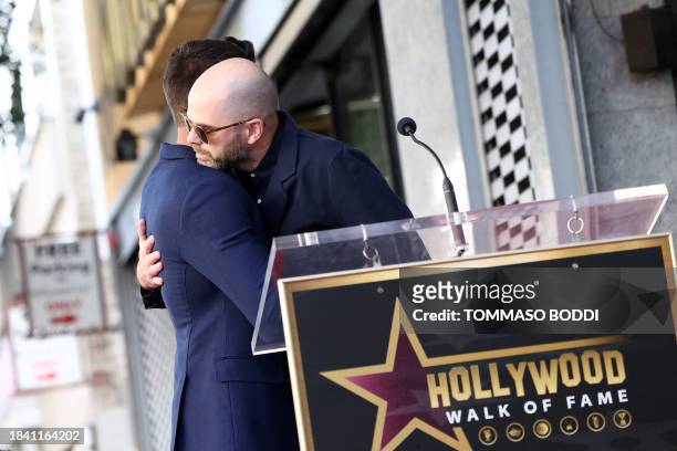 Zac Efron and Sean Durkin embrace during the ceremony honoring Efron with a Star on the Hollywood Walk of Fame on December 11, 2023 in Hollywood,...