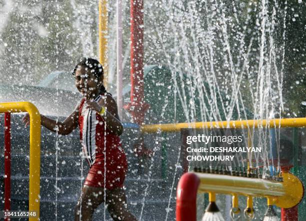 Young Indian child enjoys a water display at an artificial beach at The 'Wet-O-Wild Beach Tropicana' Water Park in Kolkata, 06 April 2007. Nicco...