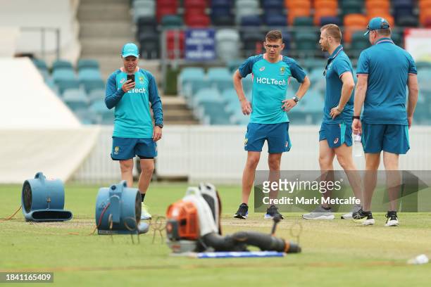 Marcus Harris; Todd Murphy and Nathan McAndrew of the Prime Ministers XI inspect the wicket during a delay to the start of play due to an overnight...