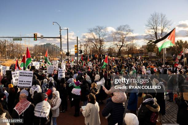 Pro-Palestinian protestors wave Palestinian flags and placards outside the Hilton Hotel where US President Joe Biden attended a fundraiser as...