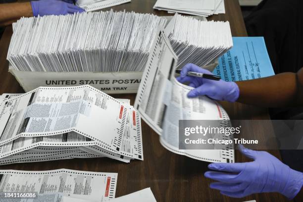 Election judges process mail-in ballots by opening envelopes and putting their initials on the ballots at the Chicago Board of Elections on Nov. 3,...