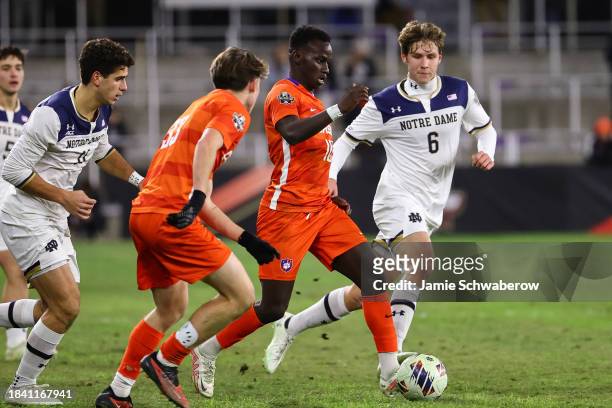 Ousmane Sylla of the Clemson Tigers carries the ball with pressure from Wyatt Lewis of the Notre Dame Fighting Irish during the Division I Men's...