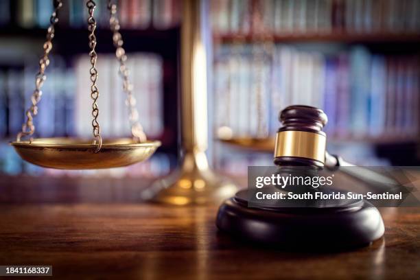 Judge gavel, scales of justice and law books in court.