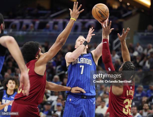 Orlando Magic forward Joe Ingles shoots between Cleveland Cavaliers center Jarrett Allen and guard Isaac Okoro at the Amway Center in Orlando,...