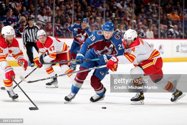 Nathan MacKinnon of the Colorado Avalanche skates against Rasmus Andersson of the Calgary Flames at Ball Arena on December 11, 2023 in Denver,...