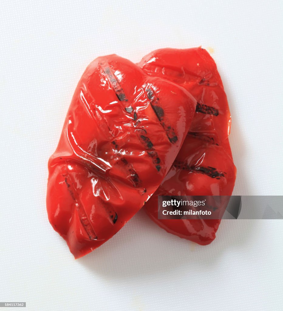 Two grilled red peppers isolated on white background