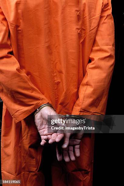 male prisoner in orange suit his arms handcuffed behind back - handbojor bildbanksfoton och bilder