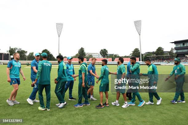 Players shake hands after the match is drawnduring day four of the Tour match between PMs XI and Pakistan at Manuka Oval on December 09, 2023 in...