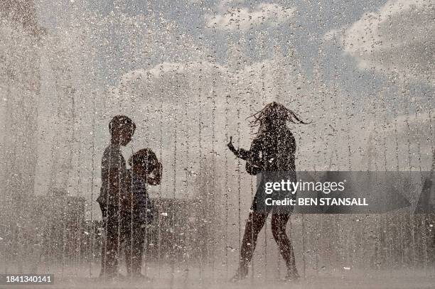 Children play in a fountain on the South Bank during a spell of fine weather in London on May 2, 2009. Southern England is experiencing a spell of...