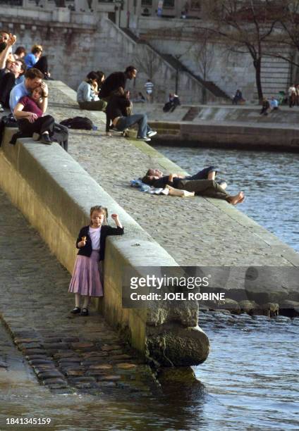Group of persons enjoy the sun on the banks of the Seine, 17 March 2004 in Paris. An unusual heatwave swept the capital sending temperatures past the...