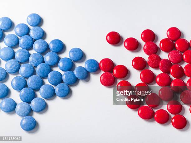 blue candy with colorful red chocolates - segregation stock pictures, royalty-free photos & images