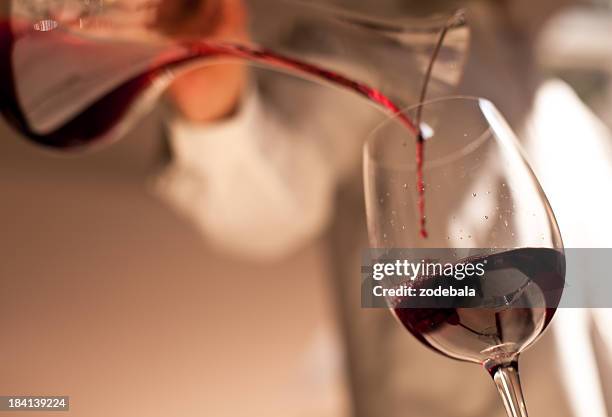 dinner, pouring the wine - rode wijn stockfoto's en -beelden