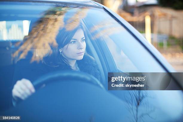 young serious woman is driving a car - car front view stock pictures, royalty-free photos & images