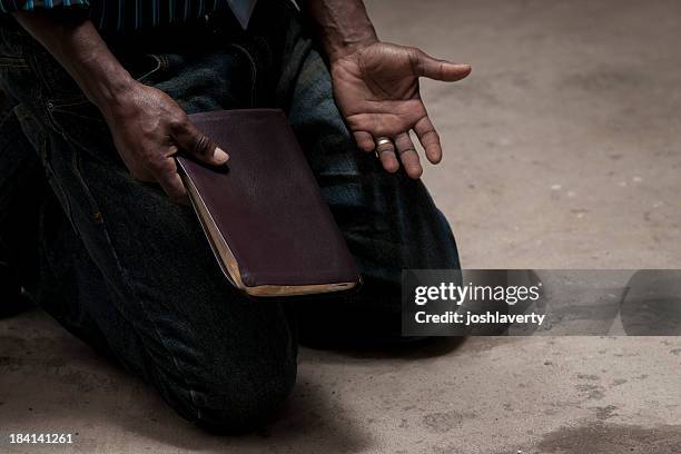 kneeling with bible - kneeling stock pictures, royalty-free photos & images