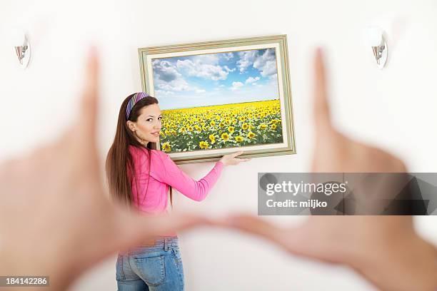 hanging a painting in new home - hanging picture frame stock pictures, royalty-free photos & images