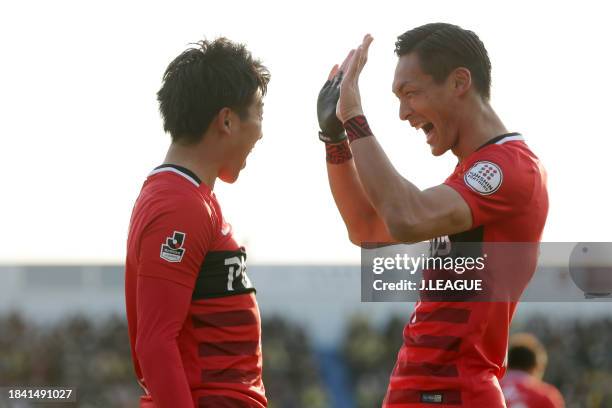 Yuki Muto of Urawa Red Diamonds celebrates with teammate Tomoaki Makino after scoring the team's first goal during the J.League J1 first stage match...
