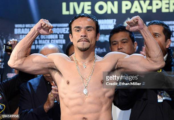 Boxer Juan Manuel Marquez poses on the scale during the official weigh-in for his bout against WBO welterweight champion Timothy Bradley Jr. At the...