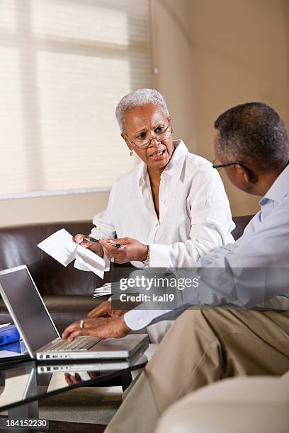 senior african american couple paying bills online - demonstration against the marriage for all bill stock pictures, royalty-free photos & images