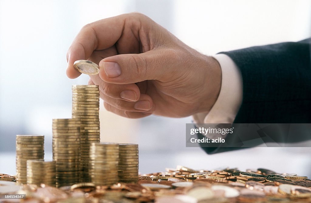 Businessman is stacking 1 Euro coins