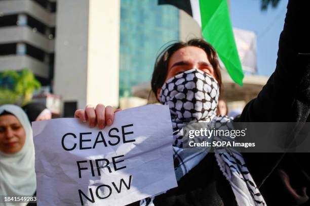 Palestinian holds a placard during a march in the center of the city of Nablus in the West Bank in solidarity with Gaza as battles continue between...