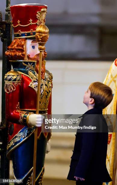 Prince Louis of Wales looks at an oversized decorative Nutcracker soldier as he attends The 'Together At Christmas' Carol Service at Westminster...