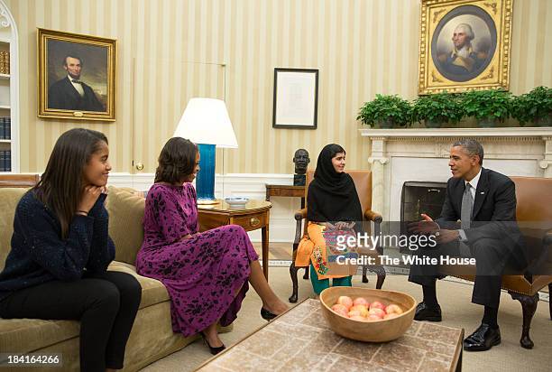 In this handout image provided by the White House, U.S. President Barack Obama , first lady Michelle Obama , and their daughter Malia Obama meet with...