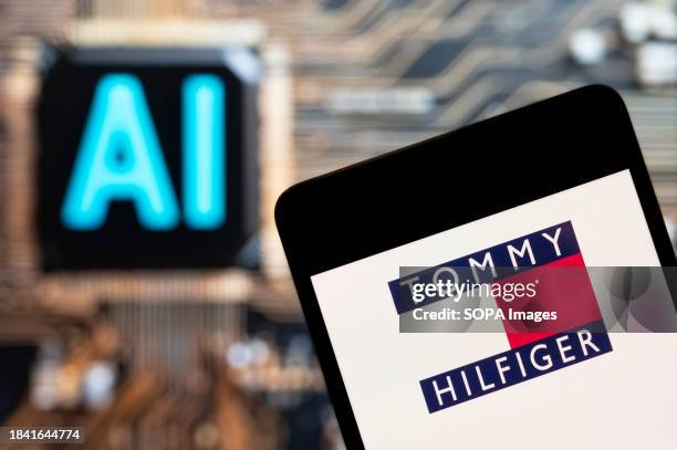 In this photo illustration, the American fashion brand Tommy Hilfiger logo seen displayed on a smartphone with an Artificial intelligence chip and...